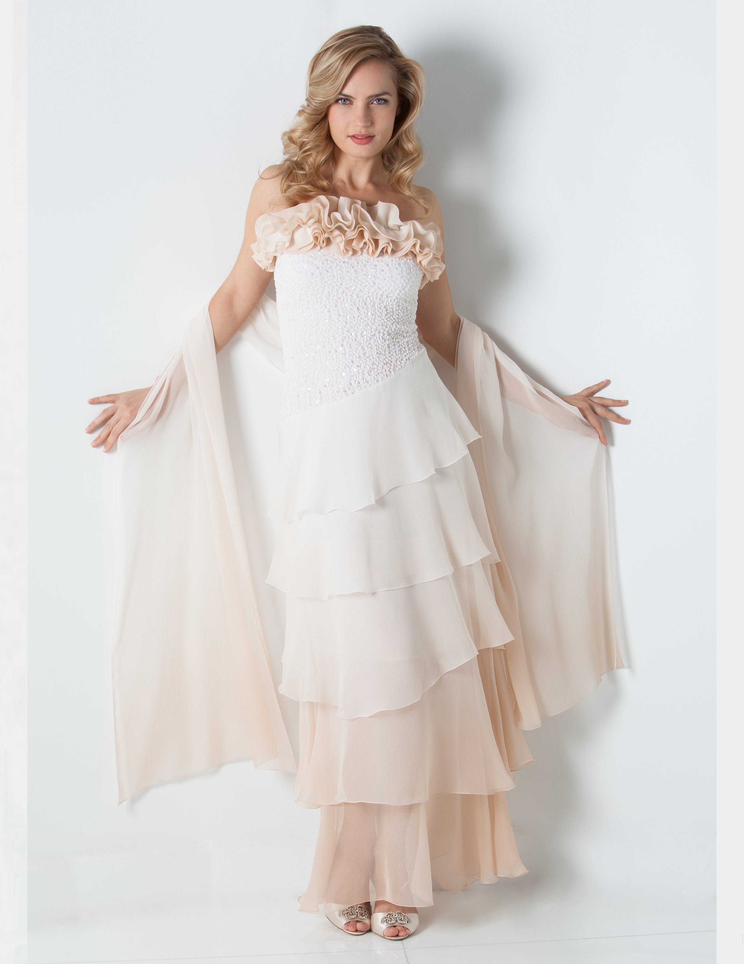 Woman wearing a strapless dress with a sequin bodice and a silk stole on a white background