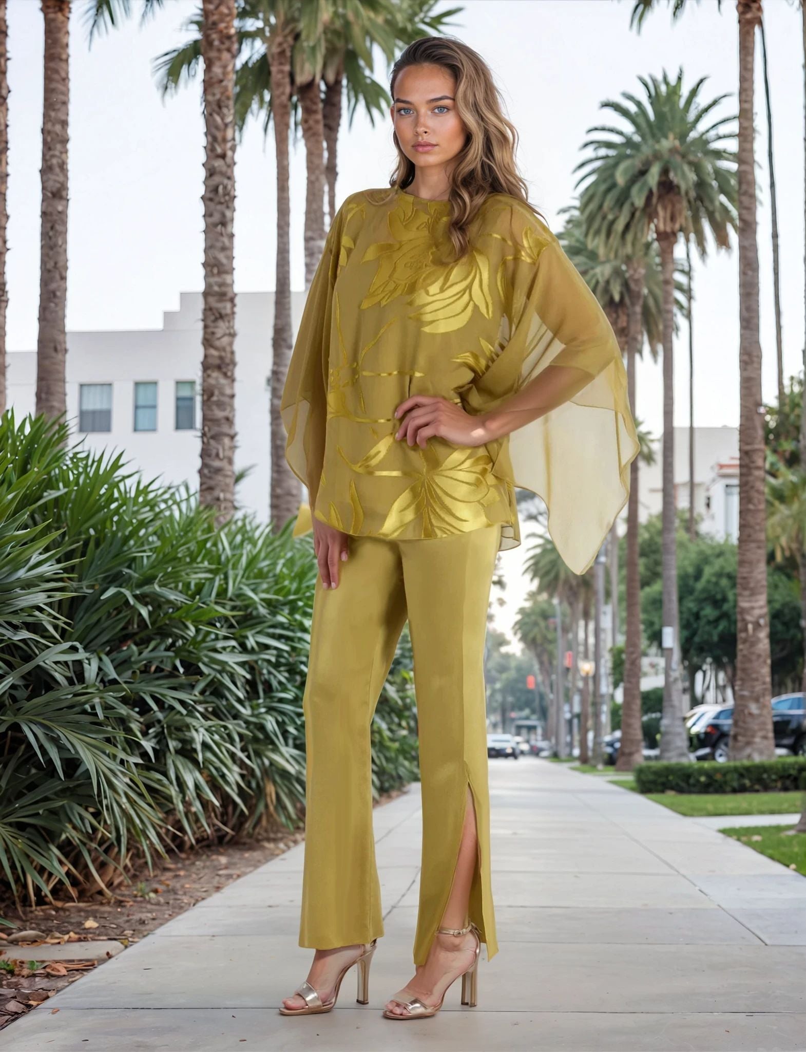 Woman in a green outfit walking on a sidewalk with palm trees in the background