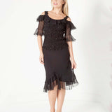 Woman wearing a black silk with sheer sleeves with a skirt on a white background