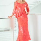 Woman wearing a coral outfit standing indoors with a white background