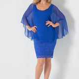Woman wearing a blue outfit with a sheer overlay on a white background