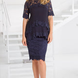 Woman wearing a navy lace dress on a white background