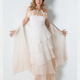 Woman wearing a strapless dress with a  sequin bodice and a silk stole on a white background