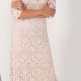 Woman wearing a long, off-shoulder lace dress on a white background