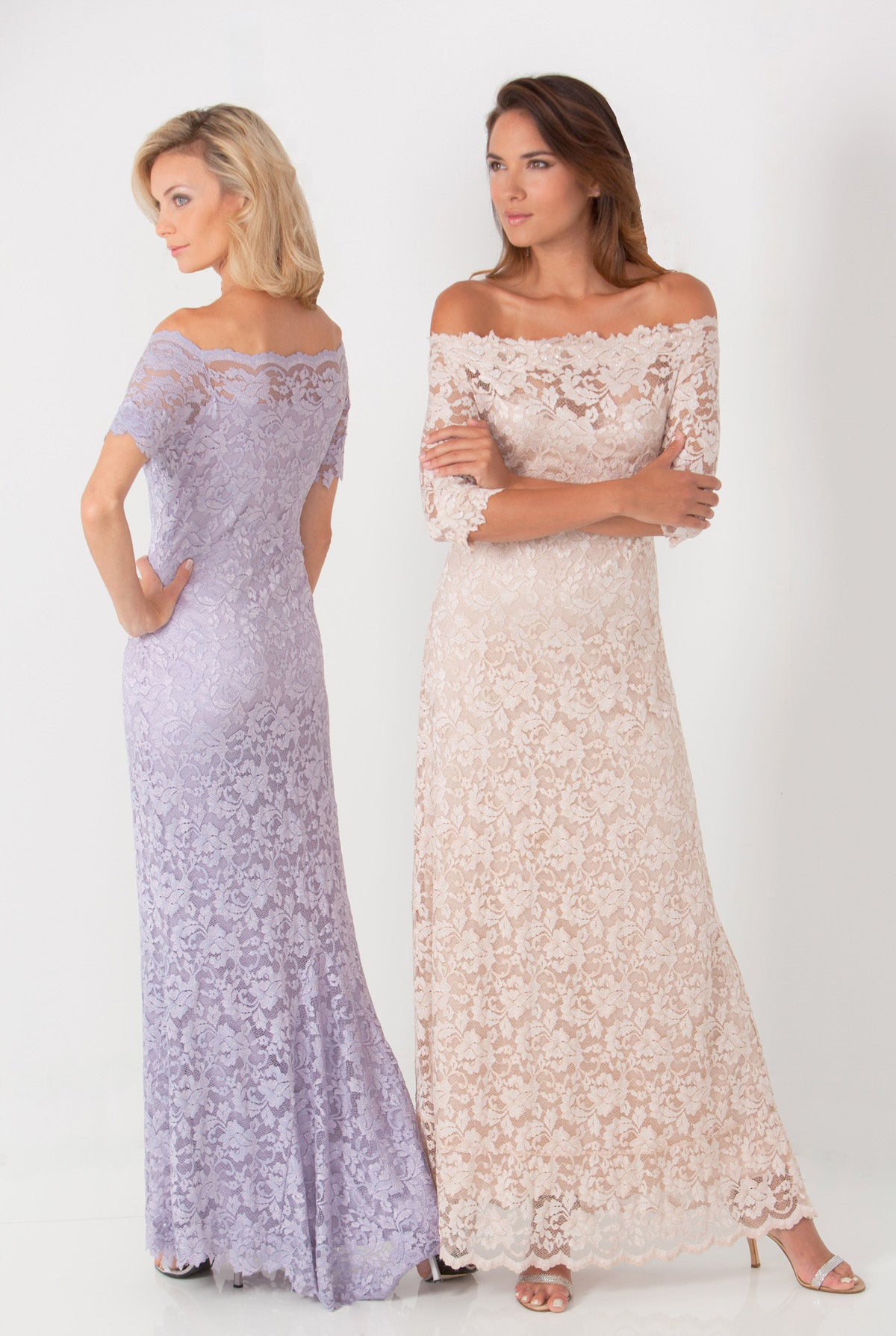 Two women wearing long lace dresses on a white background