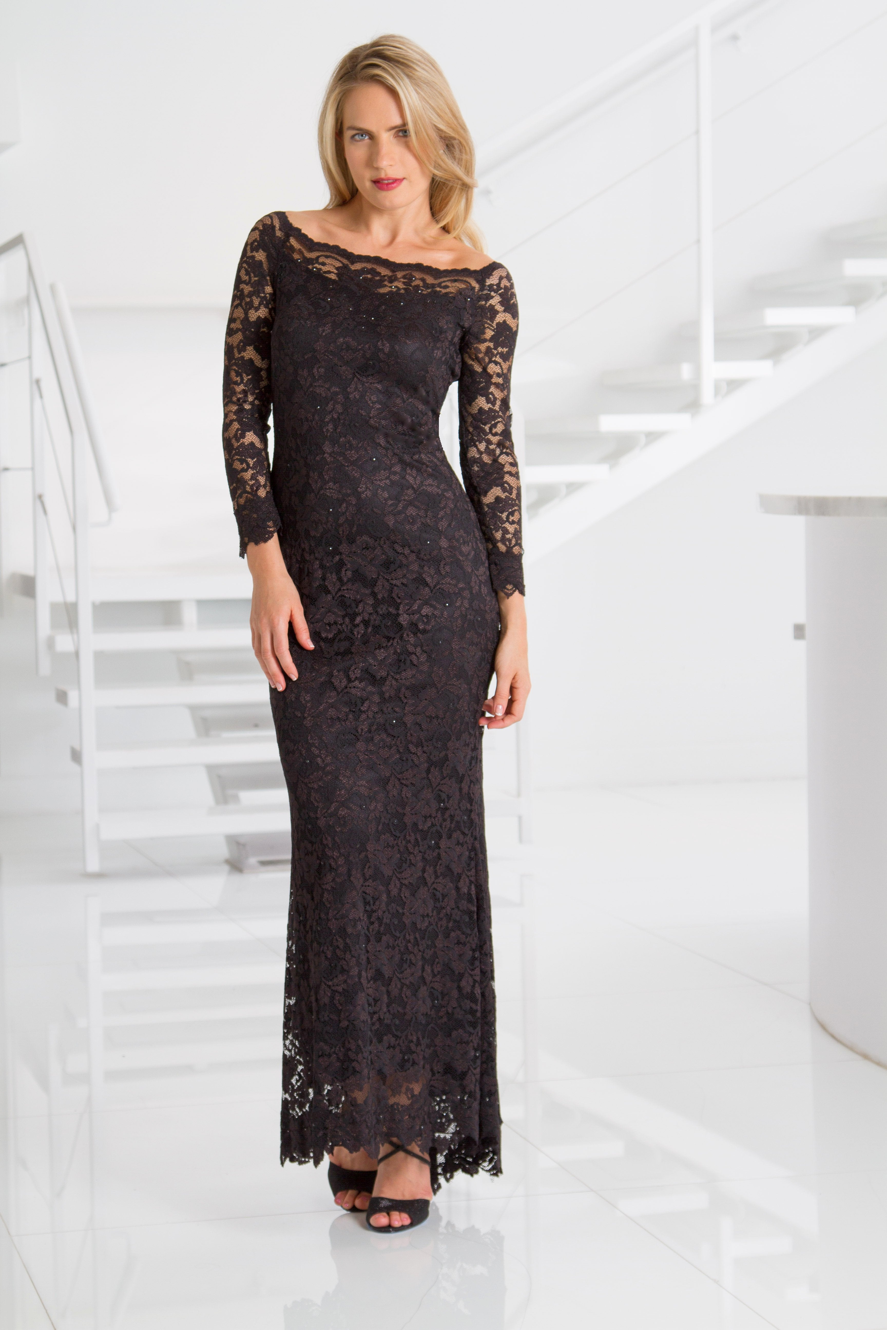Woman wearing a black lace dress in a white interior setting