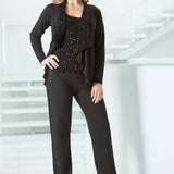 Woman in a black pant outfit standing in a minimalistic setting with white stairs.