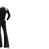 A model wearing a black sequin halter neck top with cold shoulder sleeves and matching pants.