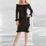 Woman wearing a black off-shoulder top and skirt with ruffled details on a white background