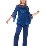 A woman models the Sara Mique Evening Wear Silk Devore Bias Blouse with Silk Liner Cami and Charmeuse Narrow Split Pant, featuring a sheer indigo floral top and matching split-hem pants, smiling gently with arms slightly raised.