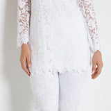 Woman wearing a white lace outfit against a white background