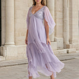 


Woman wearing a light purple dress with a sequined bodice in front of classical architecture.