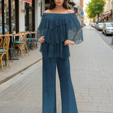 Woman in a blue outfit standing on a city street