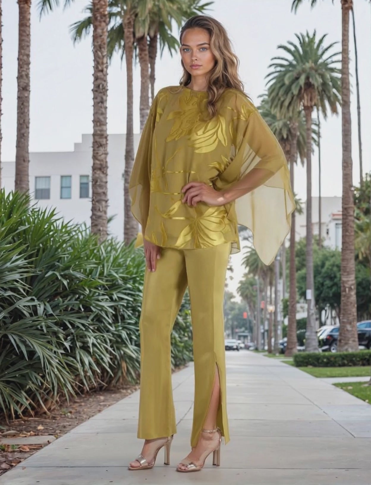 Woman in a green outfit walking on a sidewalk with palm trees in the background