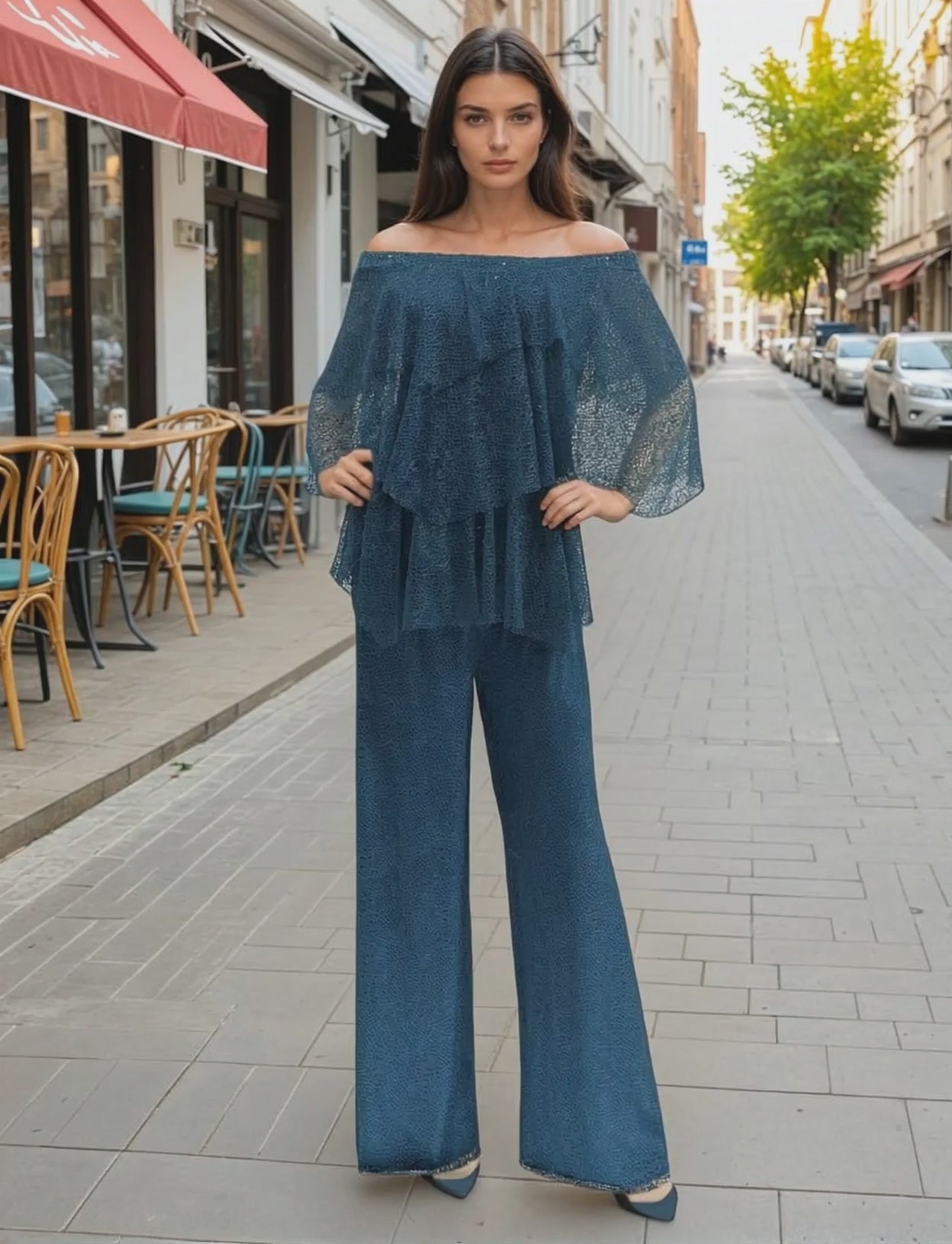 Woman wearing a teal color blouse and pant outfit on a colorful street background