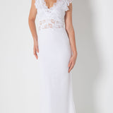Woman in Full Length French Lace and Silk Plisse' white dress standing against a white wall